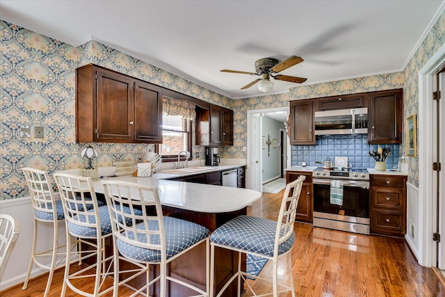 804 Camellia Rd, Augusta, GA 30909 - kitchen with appliances with stainless steel finishes, wallpapered walls, light wood-style flooring, light countertops, and a ceiling fan