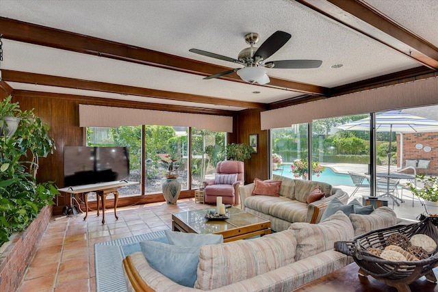 804 Camellia Rd, Augusta, GA 30909 - living room featuring beamed ceiling, a ceiling fan, wooden walls, plenty of natural light, and a textured ceiling