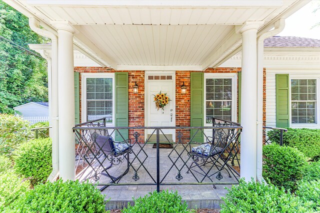 104 Sim St, Washington, GA 30673 - doorway to property featuring brick siding and covered porch