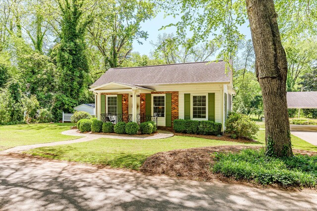 104 Sim St, Washington, GA 30673 - view of front of house featuring a porch, roof with shingles, a front yard, and brick siding