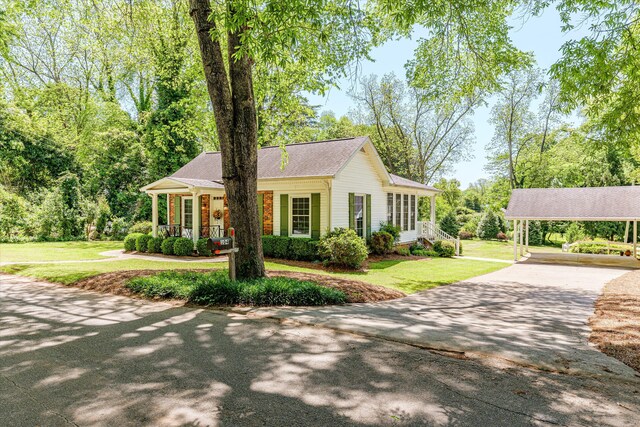 104 Sim St, Washington, GA 30673 - view of front of home featuring concrete driveway, a front yard, a carport, and covered porch