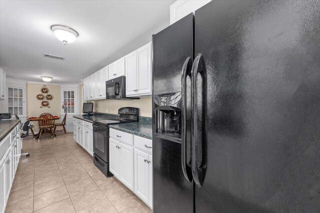 104 Sim St, Washington, GA 30673 - kitchen with black appliances, light tile patterned flooring, dark countertops, and white cabinets