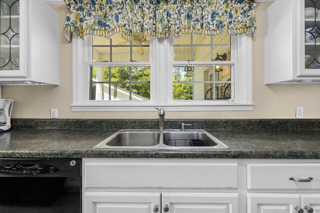 104 Sim St, Washington, GA 30673 - kitchen with black dishwasher, a sink, white cabinets, dark countertops, and glass insert cabinets