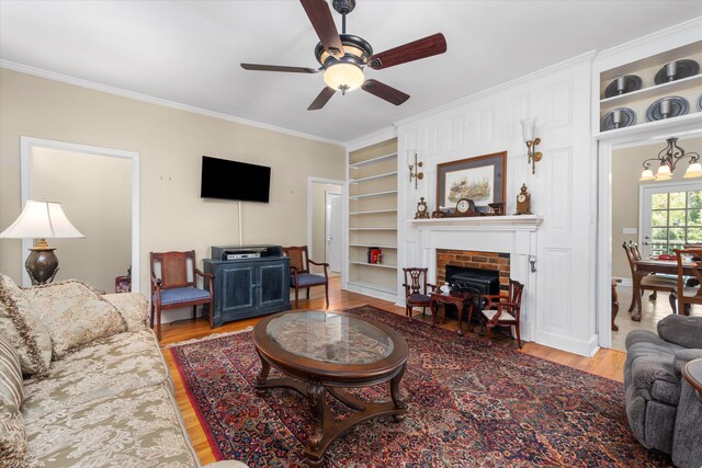 104 Sim St, Washington, GA 30673 - living room featuring built in features, a brick fireplace, crown molding, wood finished floors, and ceiling fan