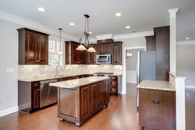 216 Dixon Ct, Evans, GA 30809 - kitchen with appliances with stainless steel finishes, decorative backsplash, light stone countertops, dark brown cabinets, and crown molding