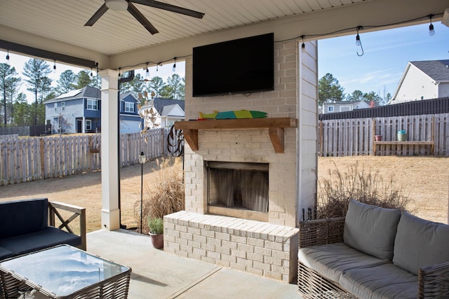 view of patio / terrace with an outdoor living space with a fireplace, a ceiling fan, and a fenced backyard