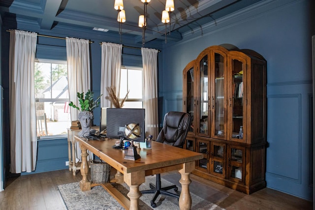 office area featuring beamed ceiling, coffered ceiling, wood finished floors, a decorative wall, and a chandelier