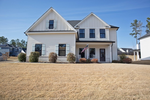 modern farmhouse style home with covered porch, board and batten siding, and a front yard