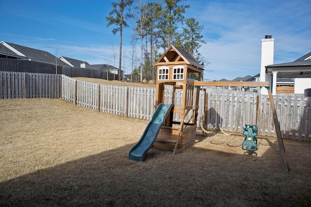 community play area featuring a yard and a fenced backyard