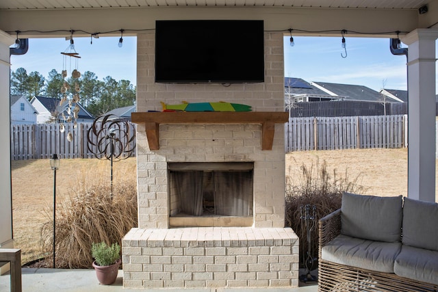 view of patio featuring a fenced backyard and an outdoor brick fireplace