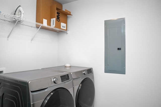 washroom with electric panel, laundry area, and separate washer and dryer