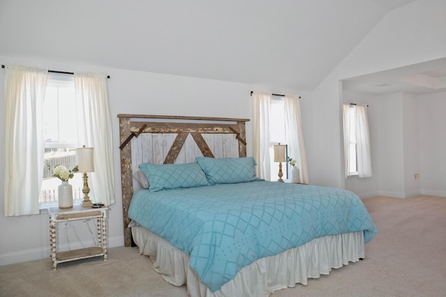 bedroom with baseboards, lofted ceiling, and carpet