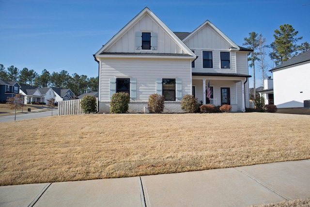 modern farmhouse style home with a front yard, a porch, and board and batten siding