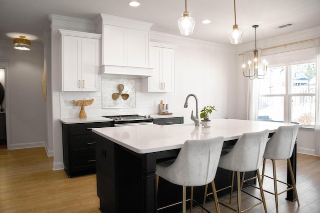 kitchen featuring visible vents, stainless steel electric range, ornamental molding, decorative backsplash, and light countertops