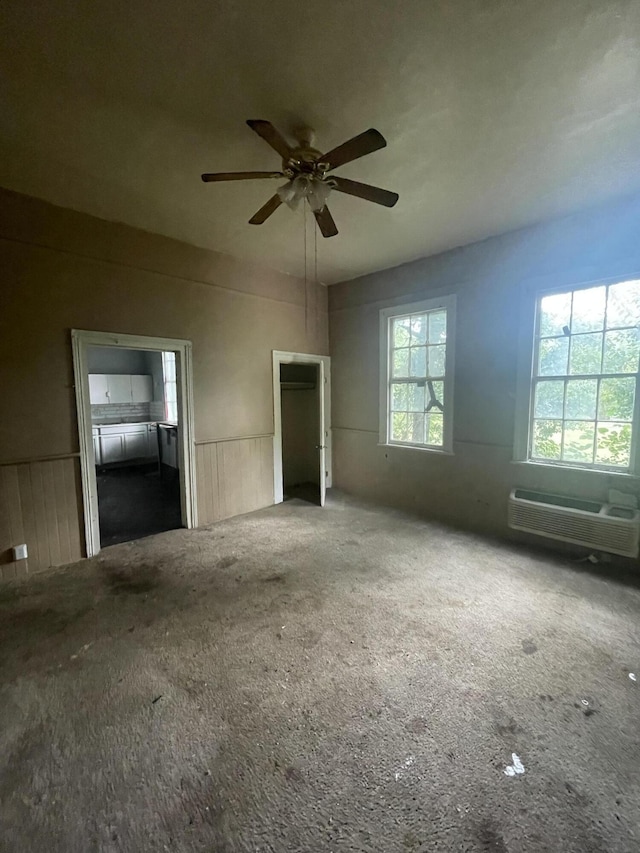210-212 Perkins St, Augusta, GA 30904 - unfurnished bedroom with carpet flooring, a wall unit AC, wainscoting, and a ceiling fan