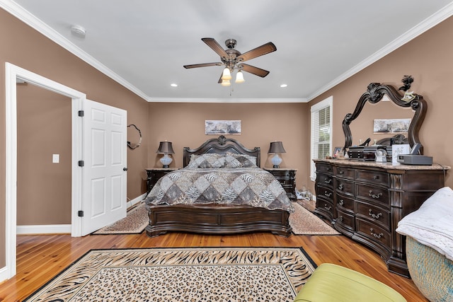 bedroom featuring light hardwood / wood-style floors, ceiling fan, and crown molding