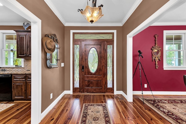 foyer entrance with dark wood-type flooring and ornamental molding