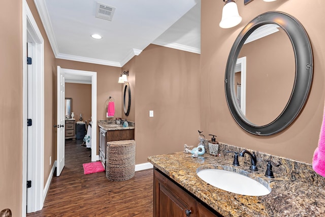 bathroom with hardwood / wood-style floors, vanity, and ornamental molding