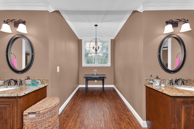 bathroom featuring hardwood / wood-style floors, vanity, a chandelier, and ornamental molding