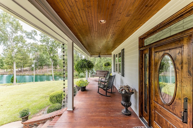 deck with a lawn, a porch, and a water view