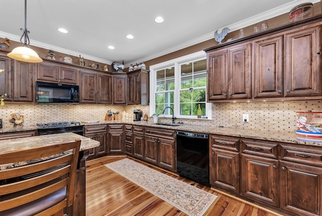 kitchen with black appliances, pendant lighting, crown molding, and sink