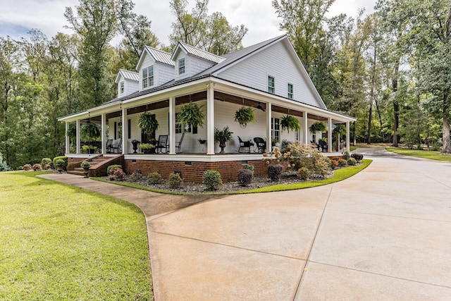 view of side of property featuring covered porch and a lawn