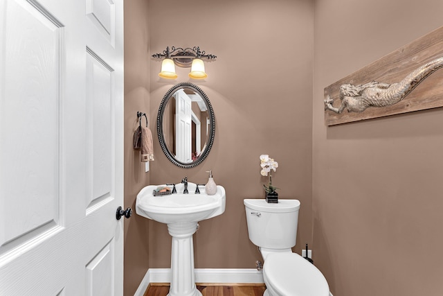 bathroom featuring hardwood / wood-style flooring, toilet, and sink