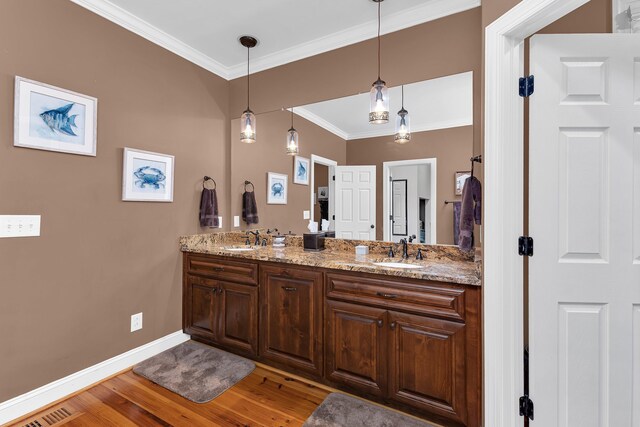 bathroom with hardwood / wood-style floors, vanity, and crown molding