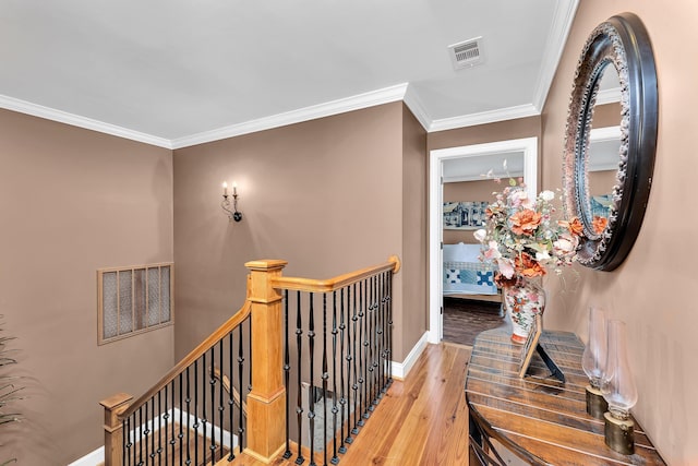 stairway with wood-type flooring and ornamental molding