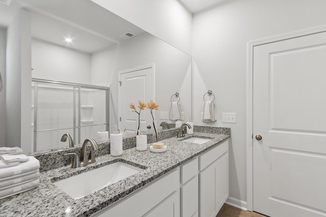 bathroom featuring vanity and a shower with door