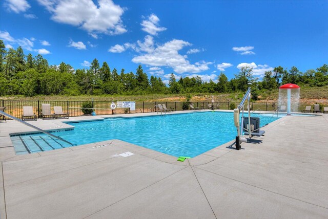 view of pool with pool water feature and a patio