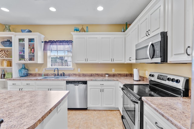 3044 Rockwell Ct, Graniteville, SC 29829 - kitchen with stainless steel appliances, white cabinets, light tile patterned floors, glass insert cabinets, and recessed lighting
