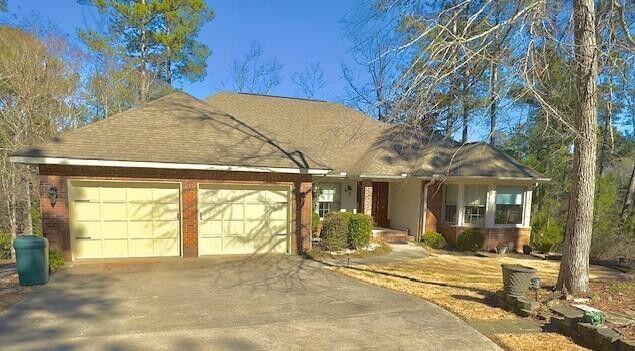 ranch-style home featuring brick siding, driveway, and a garage