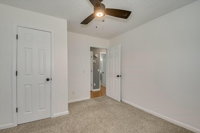 unfurnished bedroom featuring light colored carpet, ceiling fan, and baseboards