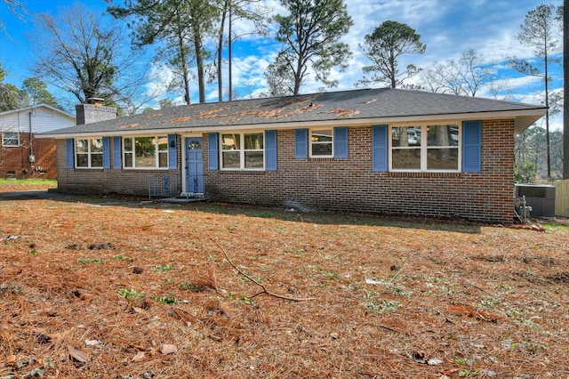 single story home with brick siding and a chimney