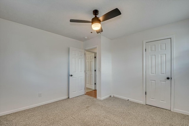 unfurnished bedroom featuring ceiling fan, baseboards, and light colored carpet