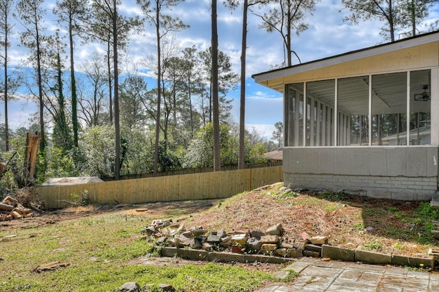 view of yard featuring a sunroom and fence