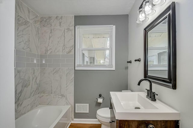 full bathroom featuring baseboards, visible vents, toilet, vanity, and a bath