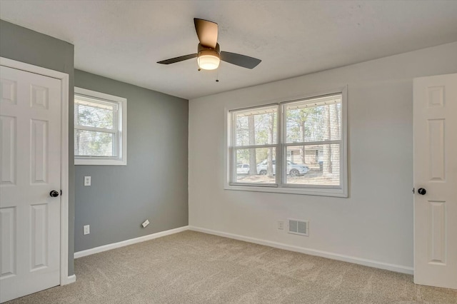 unfurnished bedroom featuring light carpet, baseboards, visible vents, and ceiling fan