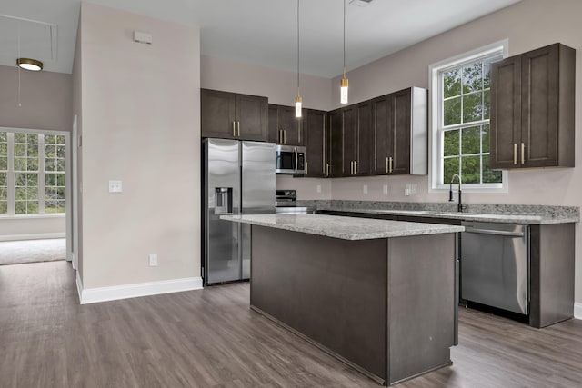 kitchen featuring dark brown cabinetry, sink, stainless steel appliances, and hardwood / wood-style flooring