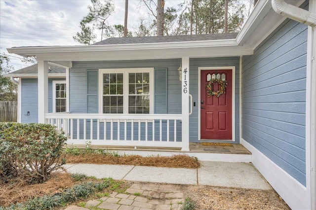 property entrance featuring a porch and roof with shingles