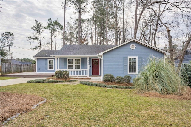 ranch-style house featuring covered porch, a front lawn, and fence