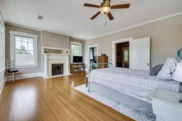 413 S Liberty St, Waynesboro, GA 30830 - bedroom with wood finished floors, a fireplace with flush hearth, baseboards, crown molding, and a ceiling fan