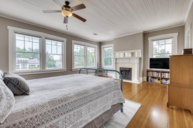 413 S Liberty St, Waynesboro, GA 30830 - bedroom with a fireplace with flush hearth, multiple windows, wood finished floors, ceiling fan, and crown molding
