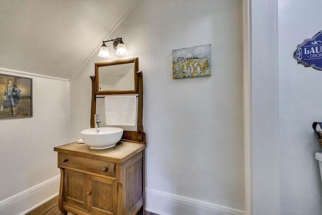 413 S Liberty St, Waynesboro, GA 30830 - bathroom featuring vaulted ceiling, vanity, baseboards, and wood finished floors