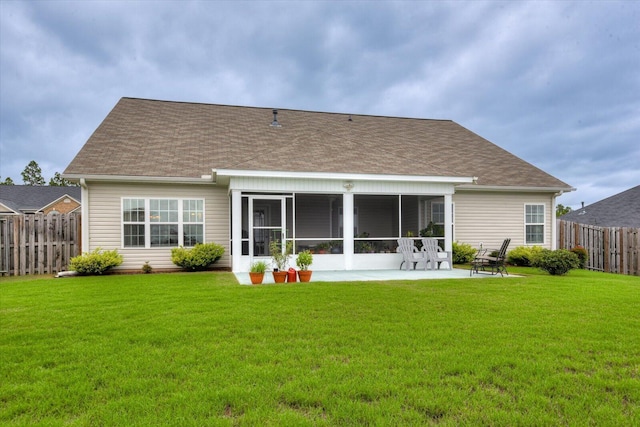 back of property with a lawn, a patio area, and a sunroom