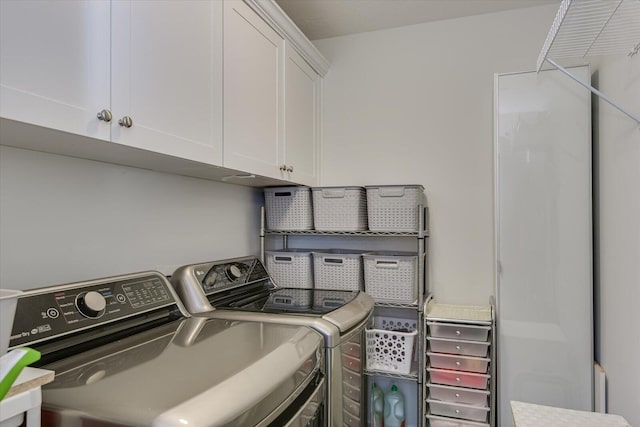 laundry room featuring cabinets and washing machine and clothes dryer