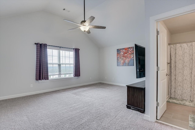 interior space with ceiling fan, lofted ceiling, and light carpet