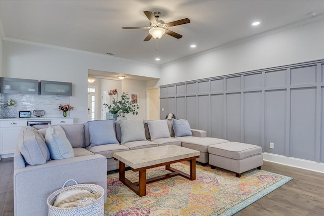 living room with wood-type flooring, ceiling fan, and crown molding