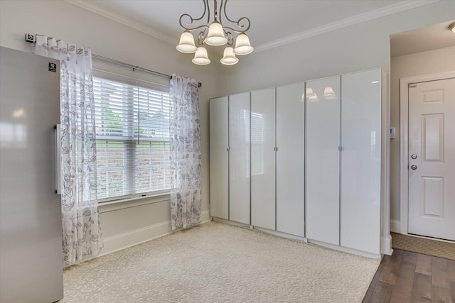 interior space with crown molding, a chandelier, fridge, and hardwood / wood-style flooring